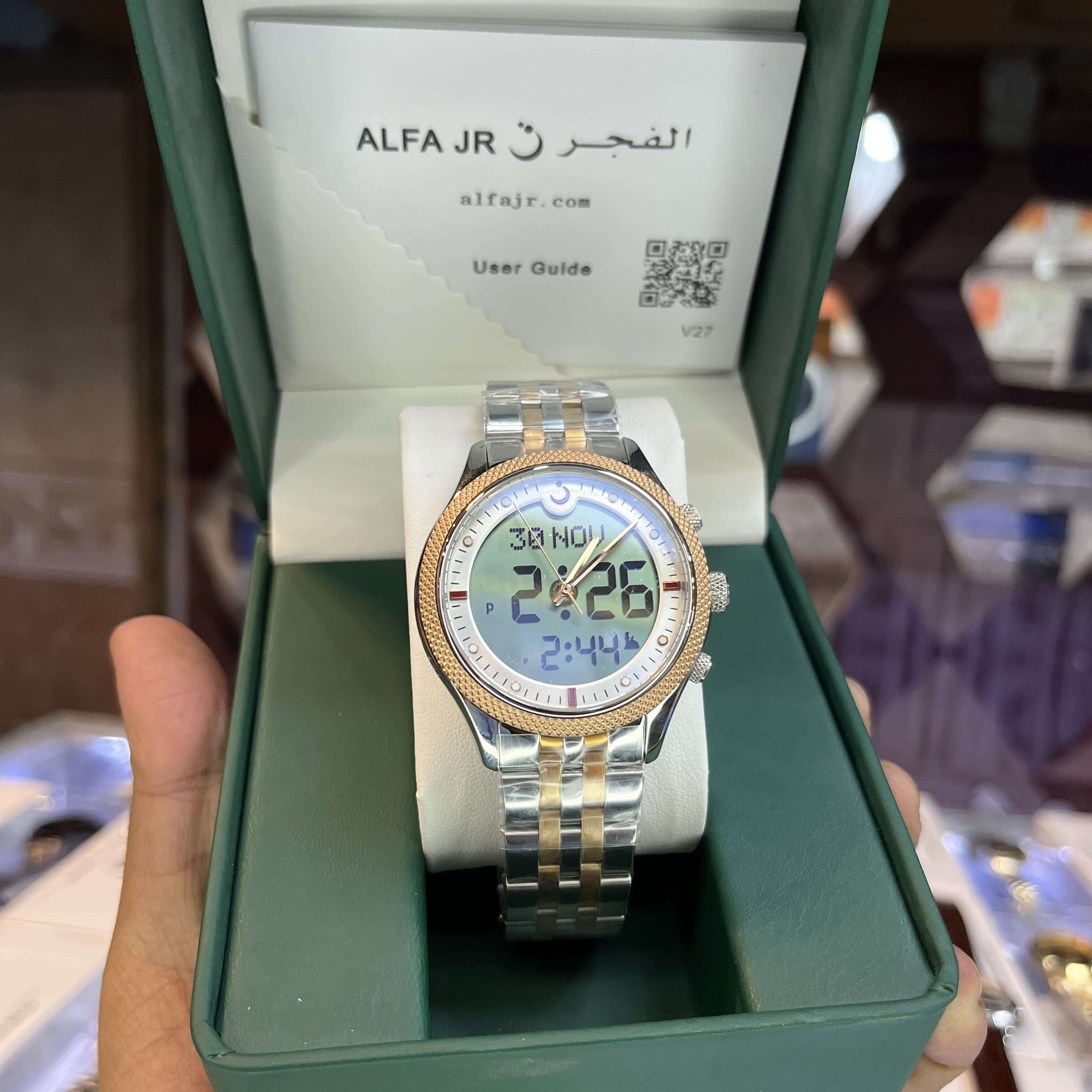 Digital watch with a gold and silver band in a green box, 
