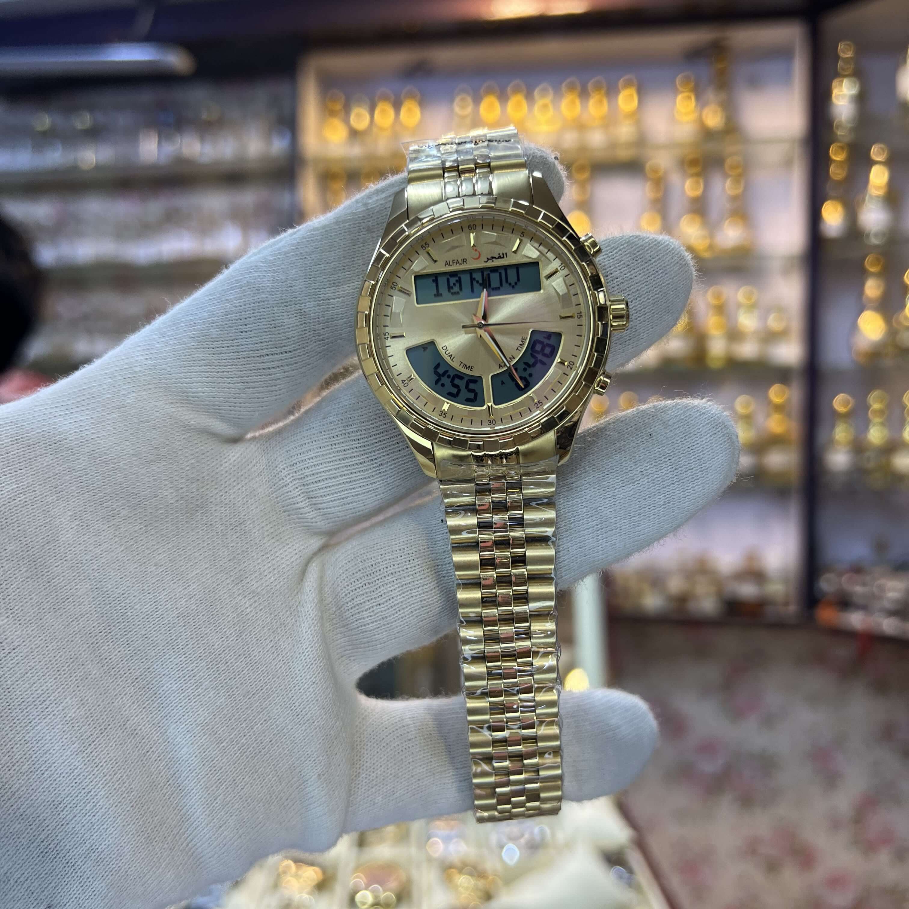 Gold wristwatch held by a gloved hand with a blurred background