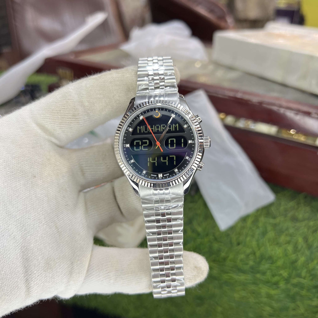 Silver wristwatch with digital display held by a gloved hand on a green surface.