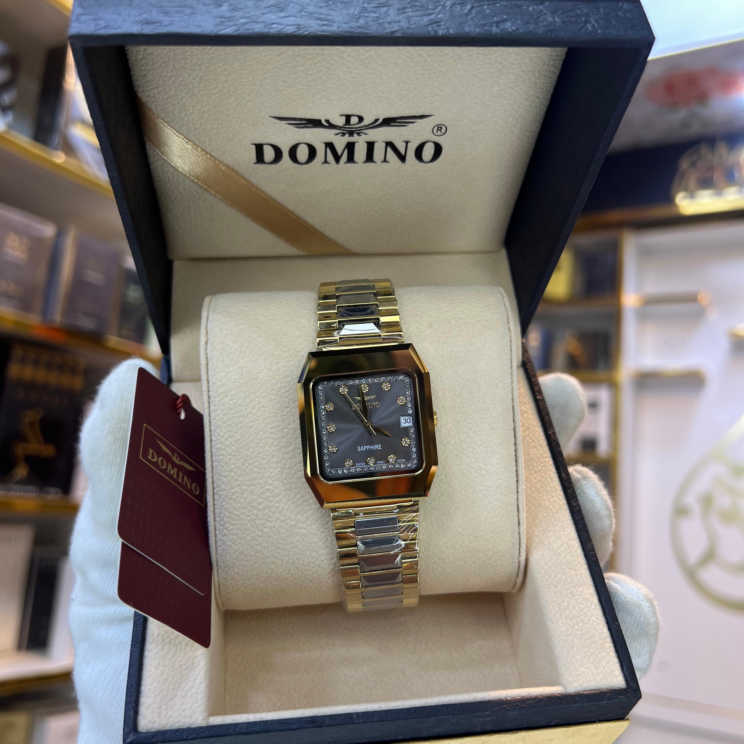 Gold watch in a DOMINO box with a visible brand logo.